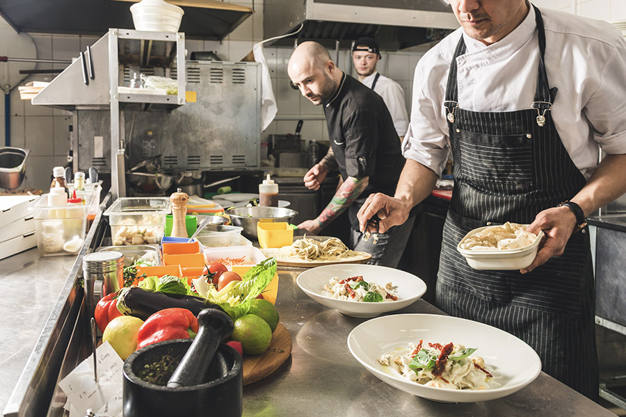Specialized Business Insurance - Restaurant Kitchen Cooks Prepping Food With Fresh Ingredients